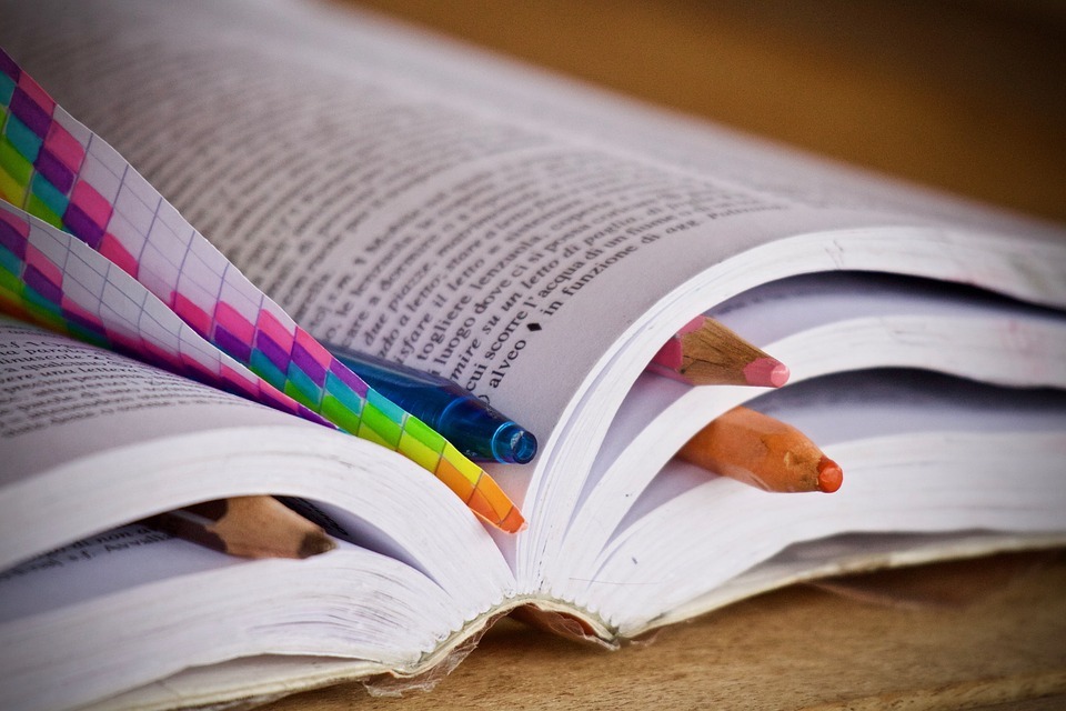 Kolorowe ołówki jako zakładki w grubej książce