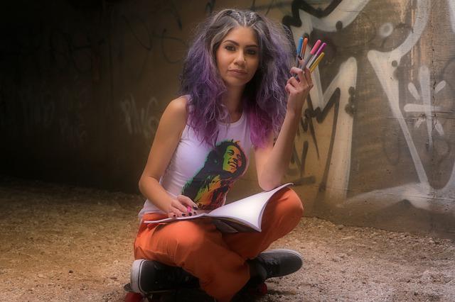 Dziewczyna w kolorowych długich włosach z markerami w dłoni